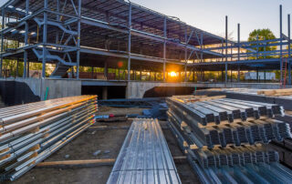 Single Source Systems pre-engineered metal building being built with a sunset in the background.