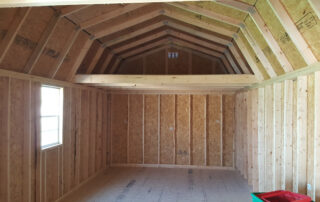 Inside of a barn built by Single Source Systems that is brown with a window on the left.