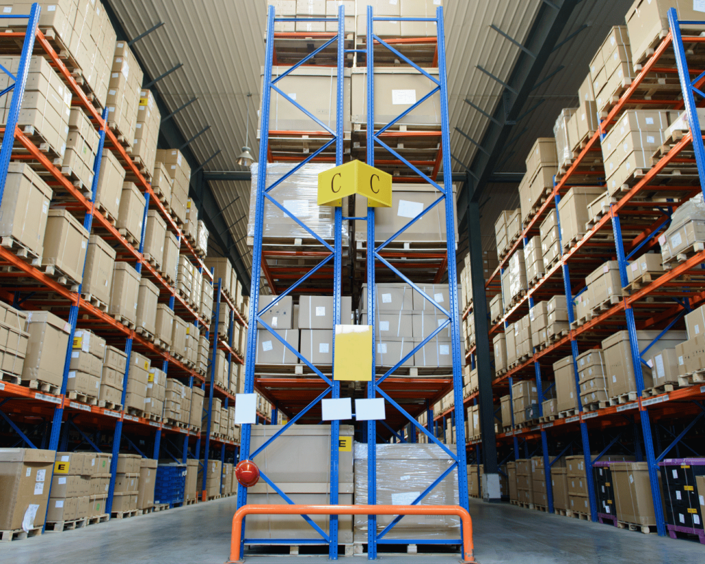 Shelving in a warehouse with cardeboard boxes stacked.