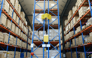 Shelving in a warehouse with cardeboard boxes stacked.